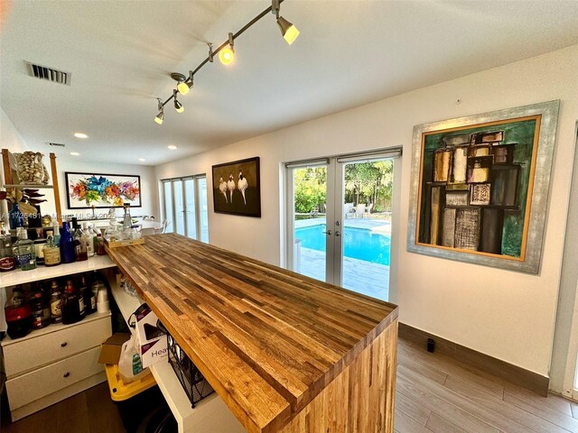 dining area with rail lighting, french doors, and hardwood / wood-style floors