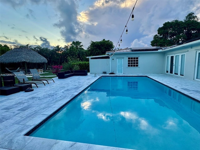 pool at dusk with a gazebo and a patio