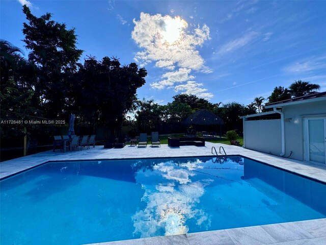 view of pool with french doors and a patio area