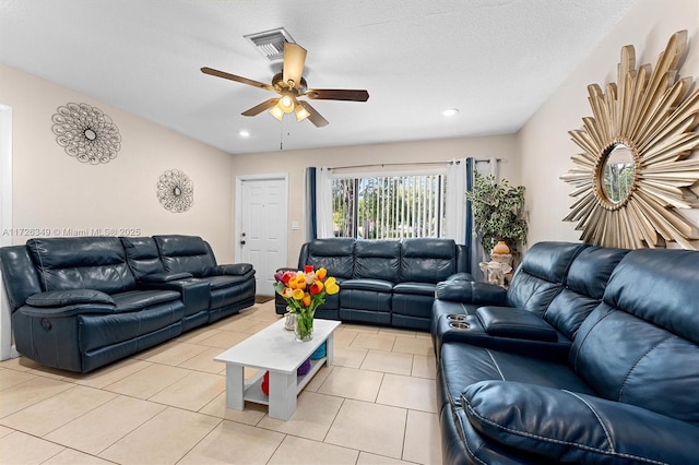 living room with a textured ceiling, ceiling fan, and light tile patterned flooring