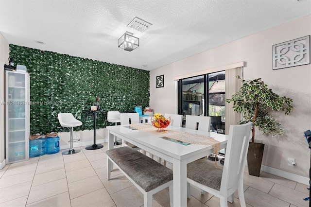 dining room with a textured ceiling and light tile patterned floors