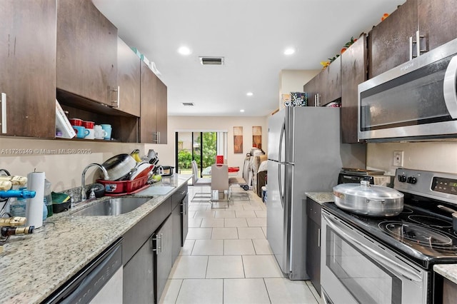 kitchen featuring stainless steel appliances, sink, and dark brown cabinetry