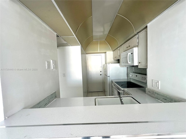 kitchen with sink, white appliances, and backsplash