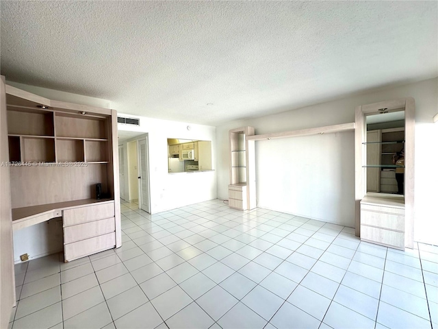 unfurnished living room with a textured ceiling and light tile patterned flooring