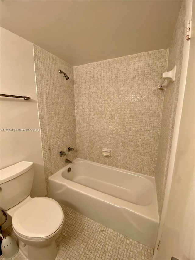 bathroom with bathing tub / shower combination, tile patterned flooring, and toilet