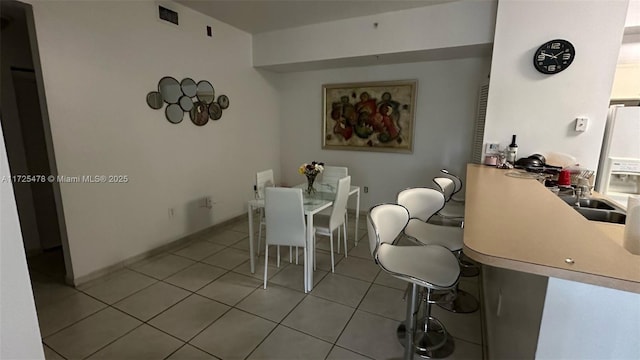 dining space with sink and light tile patterned floors