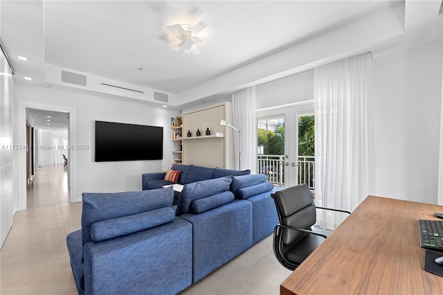 tiled living room featuring french doors, ceiling fan, and a tray ceiling