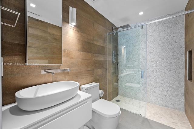 bathroom featuring toilet, an enclosed shower, wood walls, and vanity