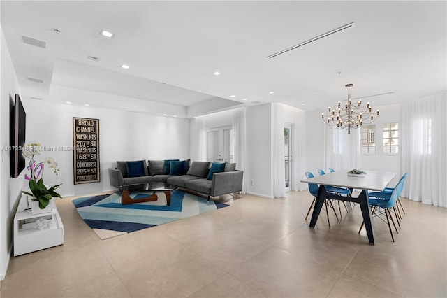 living room featuring a raised ceiling and an inviting chandelier