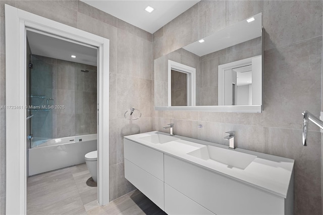 full bathroom featuring tile walls, toilet, shower / bathtub combination, and vanity