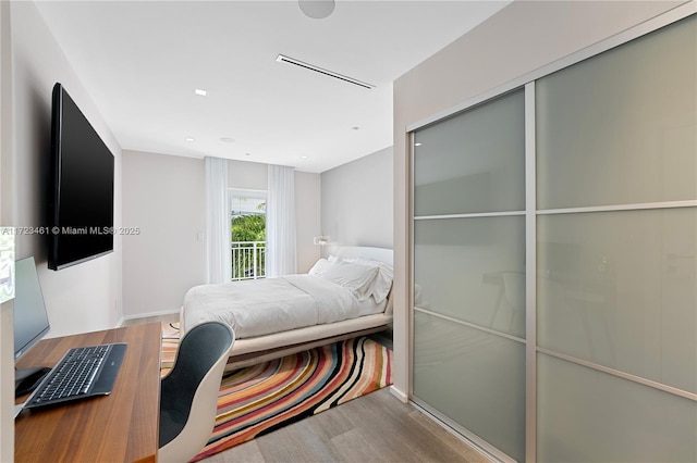 bedroom with light wood-type flooring and access to exterior