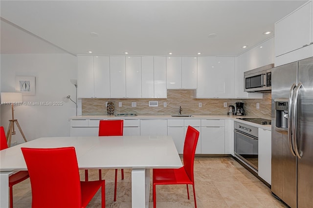 2301 Collins Ave Unit 1515, Miami Beach, FL 33139 - kitchen with backsplash, white cabinets, appliances with stainless steel finishes, and modern cabinets
