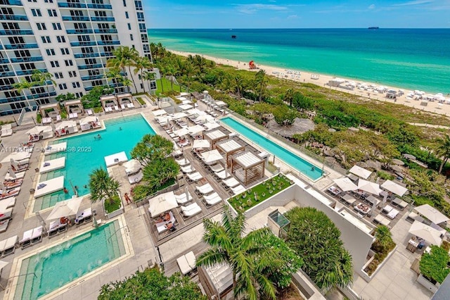 birds eye view of property featuring a beach view and a water view