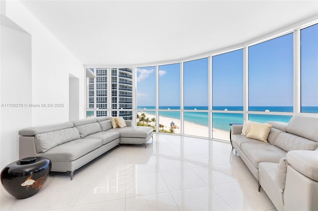 living room featuring a water view, light tile patterned flooring, and expansive windows