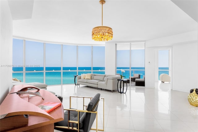 living room featuring a notable chandelier, light tile patterned floors, and a water view