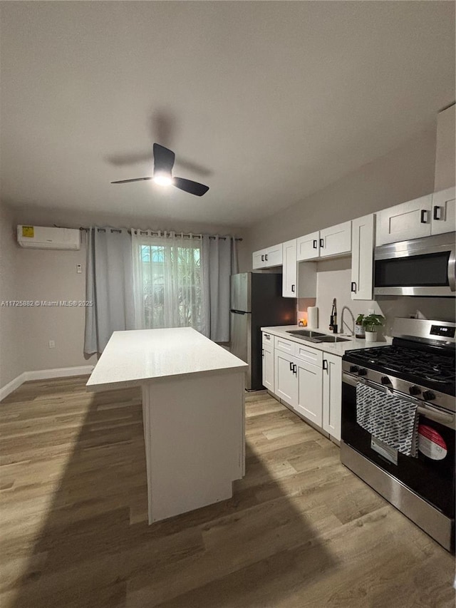 kitchen featuring appliances with stainless steel finishes, white cabinets, sink, and a kitchen island