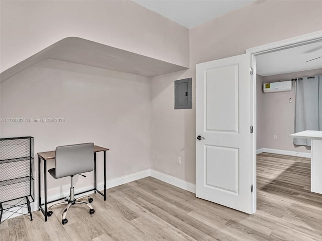 home office featuring a wall mounted air conditioner, electric panel, and light hardwood / wood-style flooring