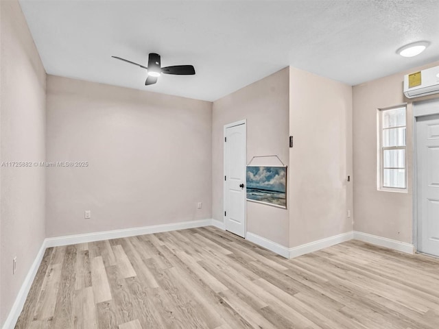 unfurnished room featuring ceiling fan, light hardwood / wood-style floors, and a wall mounted AC