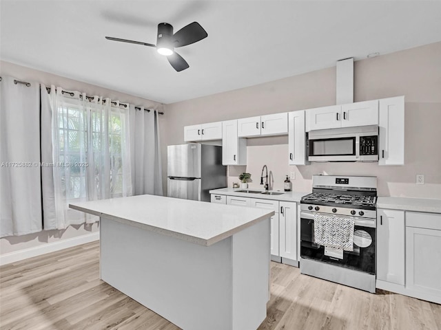 kitchen with white cabinetry, sink, light wood-type flooring, and appliances with stainless steel finishes