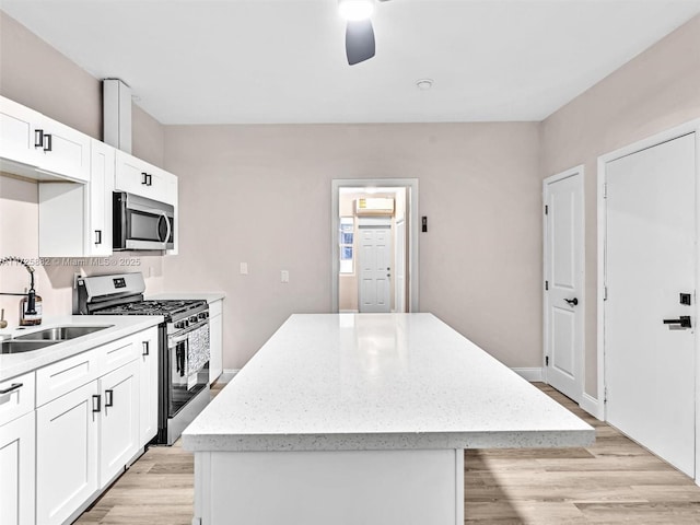 kitchen with a kitchen island, white cabinets, and appliances with stainless steel finishes