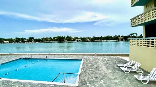 view of swimming pool with a patio and a water view