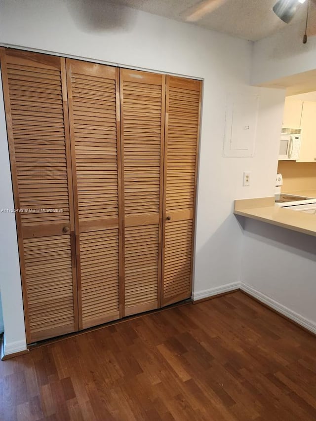 interior space with electric stove, ceiling fan, electric panel, hardwood / wood-style floors, and a textured ceiling