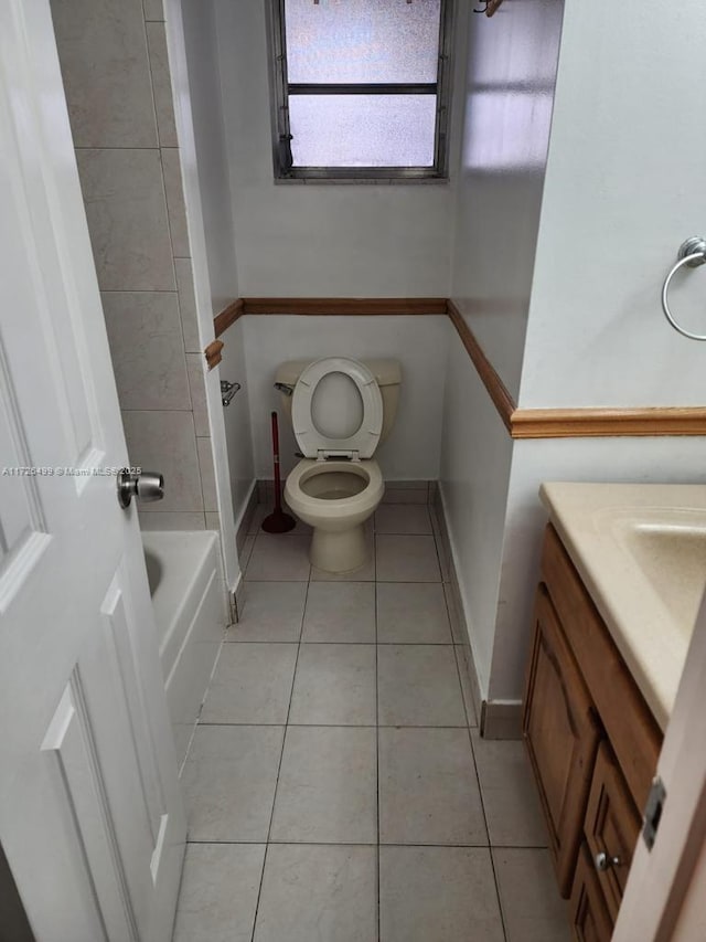 bathroom with a tub, tile patterned floors, vanity, and toilet