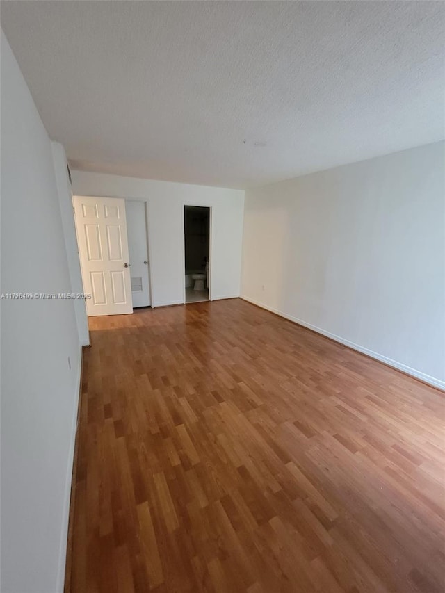 spare room with a textured ceiling and hardwood / wood-style flooring