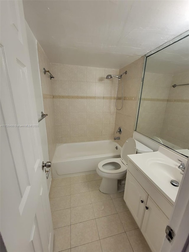 full bathroom featuring tiled shower / bath combo, vanity, toilet, and tile patterned flooring