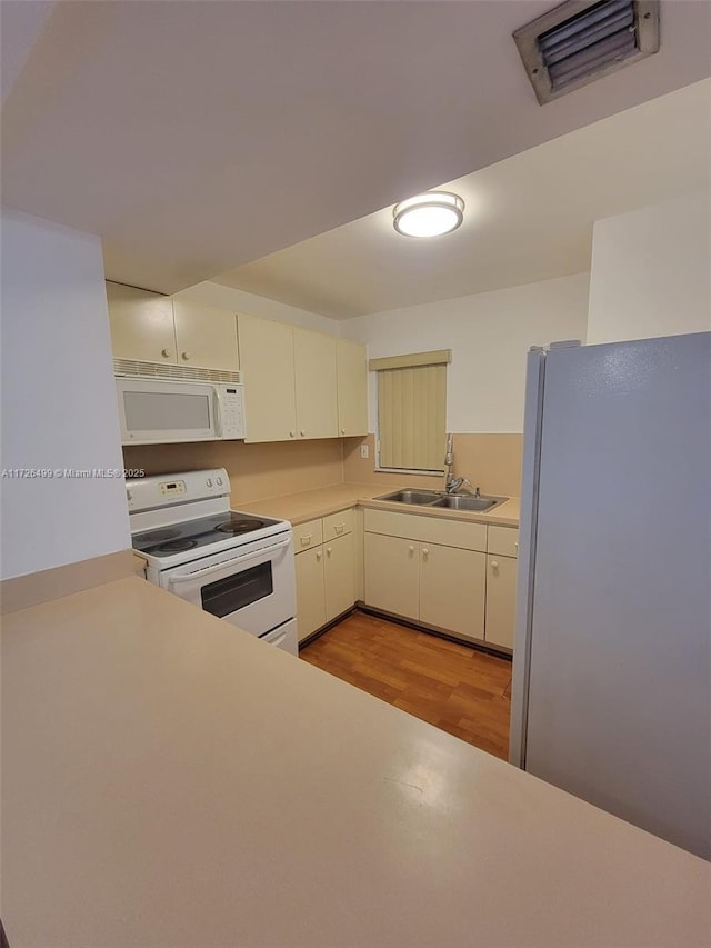 kitchen featuring light hardwood / wood-style floors, sink, and white appliances