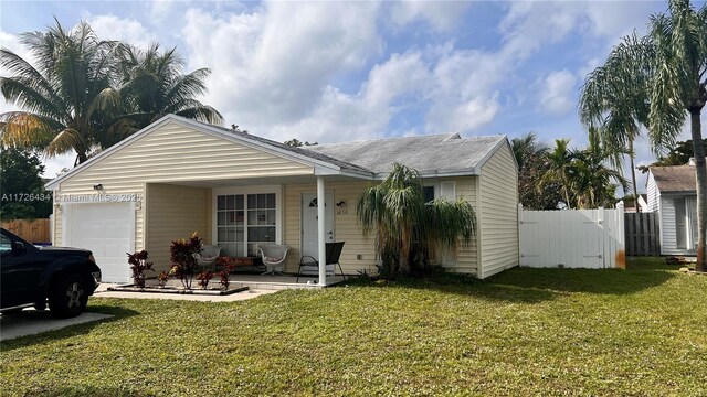 ranch-style home with a front yard and a garage