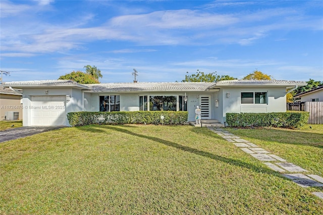 ranch-style home featuring central AC, a garage, and a front yard