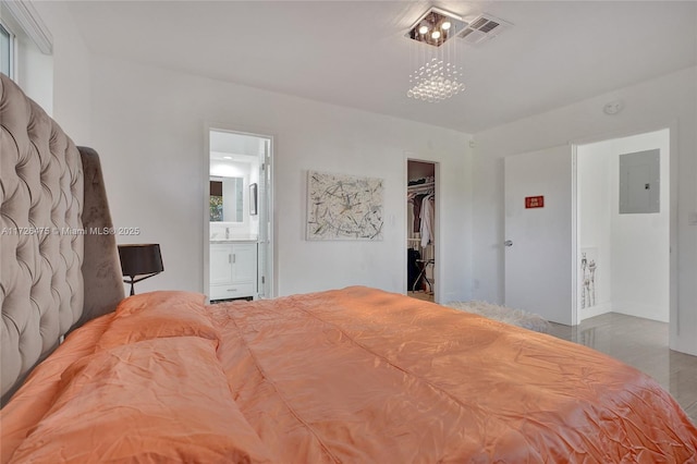 bedroom featuring ensuite bath, electric panel, a closet, and a walk in closet