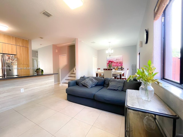 living room featuring light tile patterned flooring, a notable chandelier, and sink