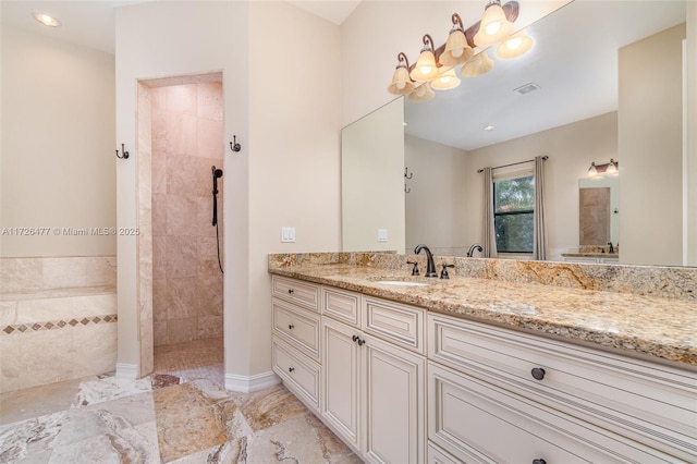 bathroom featuring tiled shower and vanity