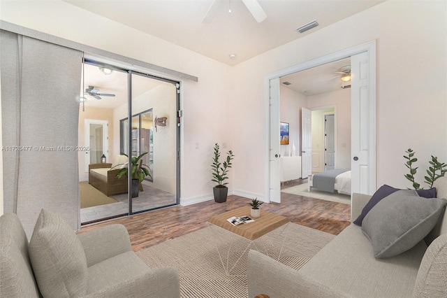 living room featuring hardwood / wood-style floors and ceiling fan