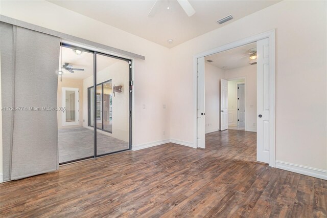 empty room featuring dark wood-type flooring and ceiling fan