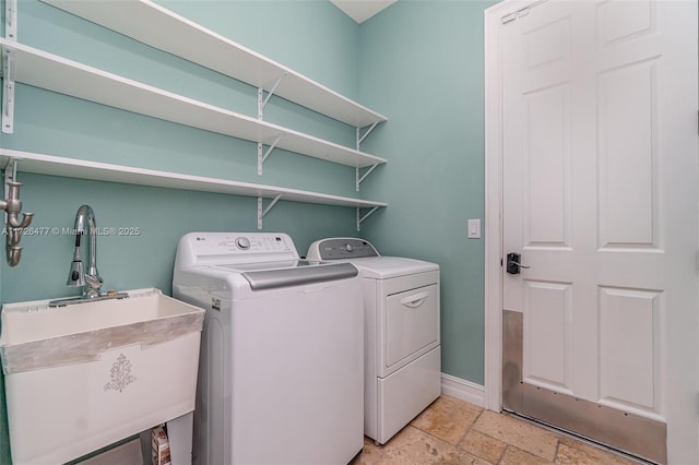 clothes washing area featuring sink and washer and dryer