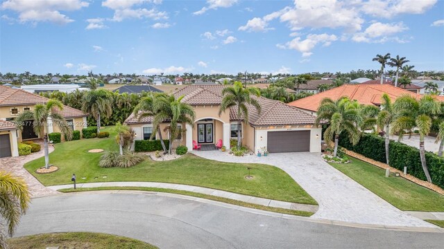 mediterranean / spanish home with a garage and a front yard