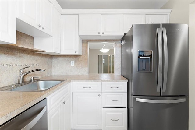 kitchen featuring stainless steel appliances, white cabinets, tasteful backsplash, and sink