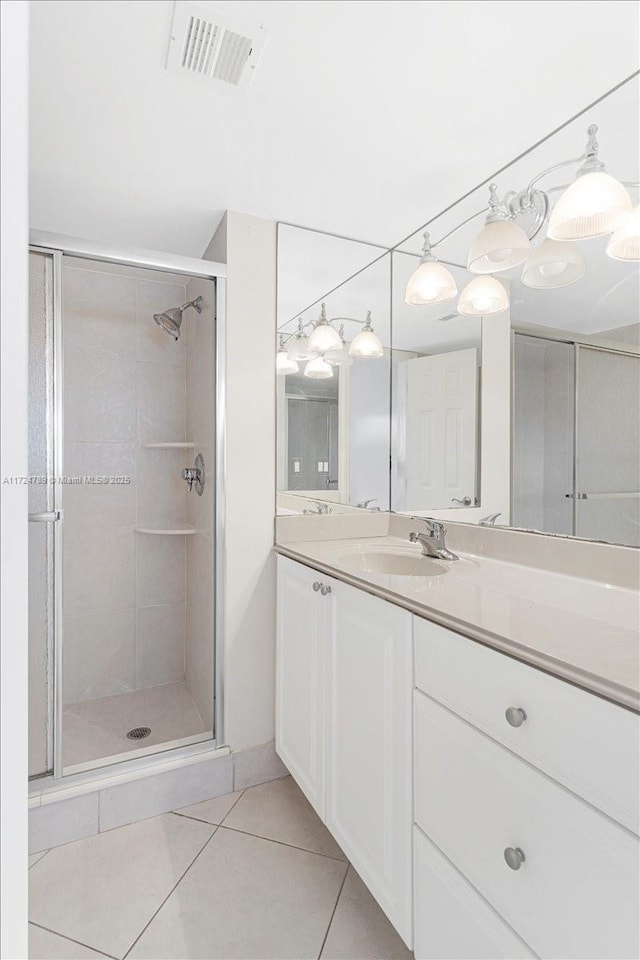 bathroom featuring walk in shower, vanity, and tile patterned floors