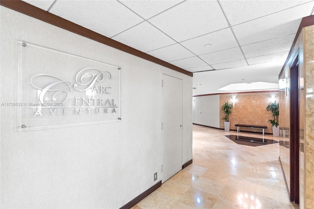 hall featuring a paneled ceiling