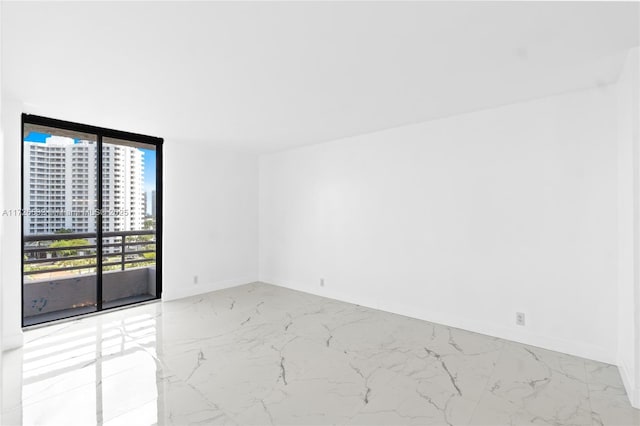 unfurnished room with a wall of windows