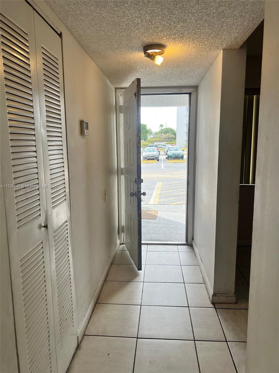 entryway with a textured ceiling and light tile patterned floors