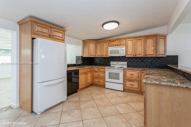 kitchen with dark stone countertops, light tile patterned floors, white appliances, and vaulted ceiling