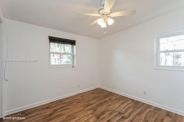 spare room with dark wood-type flooring and ceiling fan