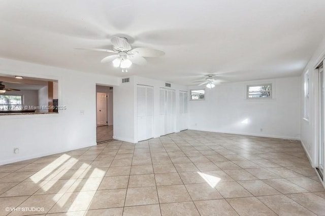 empty room with ceiling fan and light tile patterned floors