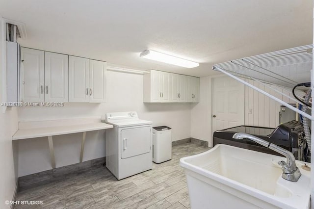 laundry room featuring washer and dryer, sink, and cabinets