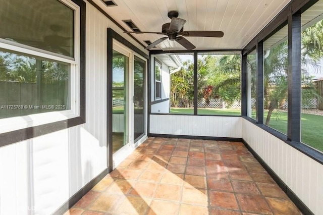 unfurnished sunroom with ceiling fan