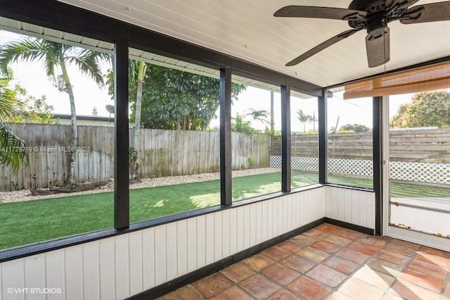 unfurnished sunroom with ceiling fan